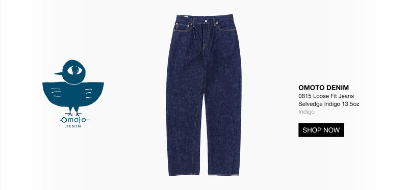 A pair of indigo blue loose fit jeans is displayed in the center. To the left is a blue bird logo with Omoto Denim text. On the right, product details and a black Shop Now button appear on a white background. 